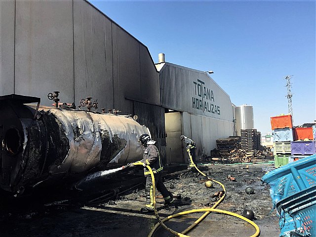 Bomberos trabajan en el incendio en una nave industrial junto al polígono de Totana